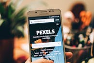 A close-up view of a smartphone displaying the Pexels website screen for stock photo searches.